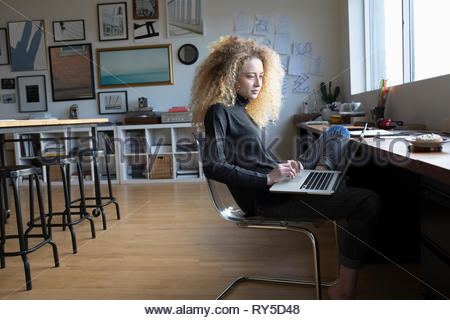 Young woman using laptop in studio