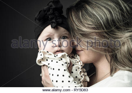 Portrait mother holding cute baby daughter