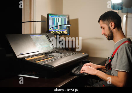 A lighting engineer works with lights technicians control on the concert show. Professional light mixer, mixing console. Equipment for concerts Stock Photo