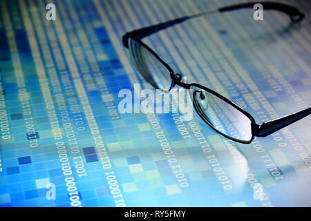 big data analysis. blue binary code on led panel with black background and glasses placed over the information panel. hacker and source code analysis. Stock Photo