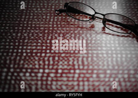 computer hacker. red dangerous code breach into red binary code with glasses place over led panel. virus, cyber threat and computer internet system fa Stock Photo