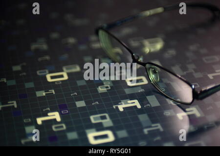 big data analysis. glasses placed on a LED digital panel display white light one and zero binary text number in moving motion pattern. modern technolo Stock Photo