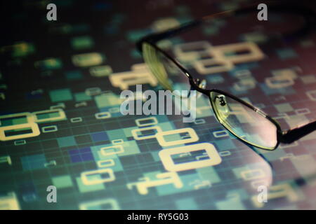 big data analysis. glasses placed on a LED digital panel display white light one and zero binary text number in moving motion pattern. modern technolo Stock Photo