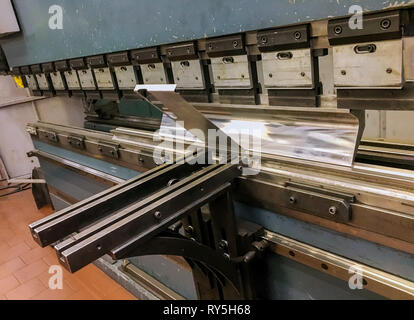 Industrial operating metal sheet profiling machine at manufacturing factory Stock Photo