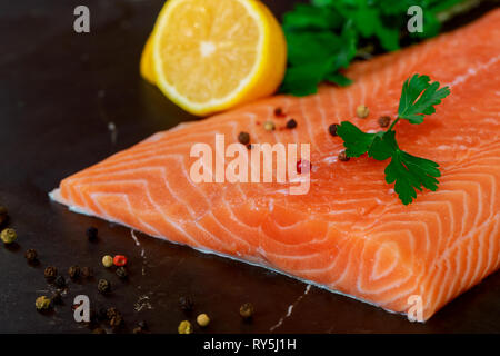 Raw salmon fillets pepper dill lemon and dill on cutting table. Stock Photo