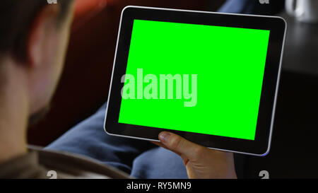 Man Sitting Using Blank Large Green Screen Tablet Stock Photo