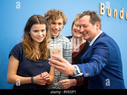 12 March 2019, Berlin: Luisa Neubauer (l-r), and Jakob Blasel, representatives of the Fridays for Future student initiative, will hold a selfie with Karen Helen Wiltshire, Deputy Director of the Alfred Wegener Institute Helmholtz Centre for Polar and Marine Research, and Eckart von Hirschhausen, doctor and science journalist, before a press conference on the subject of student protests for climate protection. Thousands of pupils in Germany want to take part in demonstrations for better climate protection next Friday as well. Photo: Monika Skolimowska/dpa-Zentralbild/dpa Stock Photo