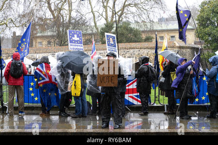 London, UK. 12th Mar, 2019. Anti Brexit protestor holds the banner 'Let The People Vote' outside The Houses Of Parliament. Credit: AndKa/Alamy Live News Stock Photo