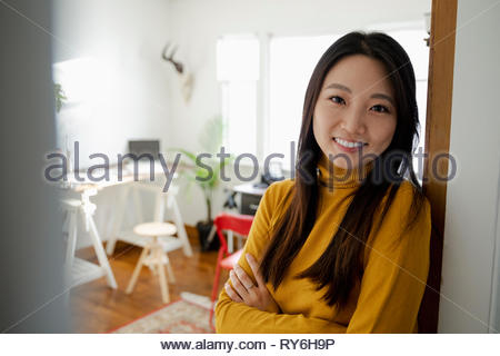 Portrait smiling, confident young woman standing in home office doorway