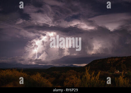Cloud to Ground lightning leaps from the side of a cloud from a complex of thunderstorms over the Sierra Madres in Sonora Mexico during the monsoon. Stock Photo