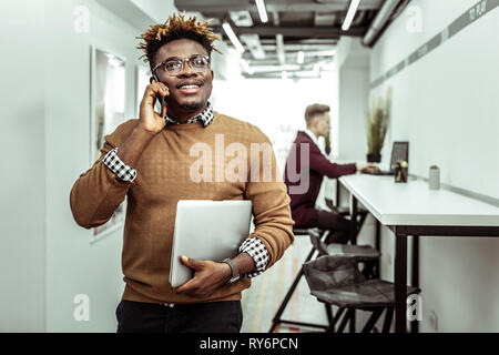 Smiling guy having pleasant conversation while going on break Stock Photo