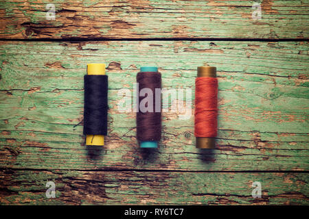 Overhead view of colorful threads on old wooden table Stock Photo
