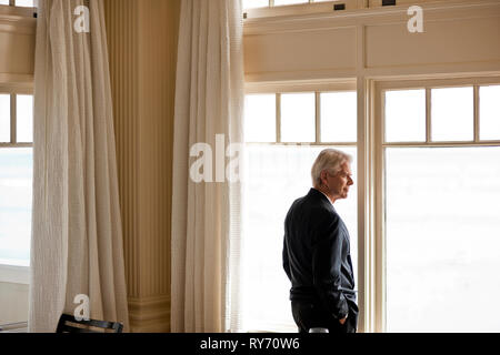 Businessman pensively looking through the window. Stock Photo