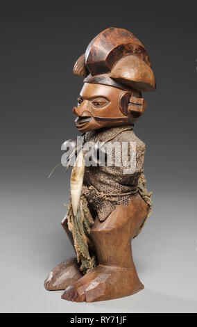 Figure, late 1800s-mid 1900s. Central Africa, Democratic Repulic of the Congo, late 19th-mid 20th Century. Wood, lizard skin, leopard tooth, seed pods, cloth; overall: 23 cm (9 1/16 in Stock Photo