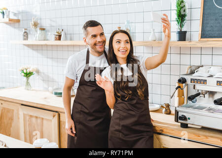cashiers standing, waving and taking selfie in coffee house Stock Photo