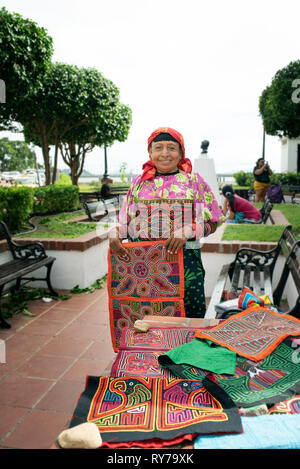 Guna woman selling her molas (hand-made textile designs made of a number of layers by hand stitches) near Paseo de las Bóvedas, Panama City, Panama Stock Photo