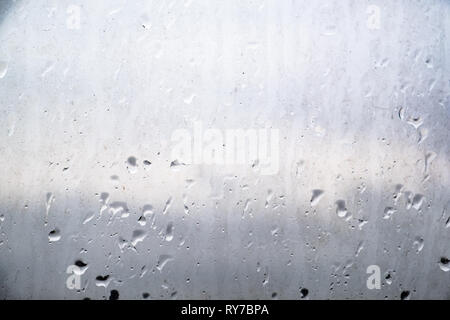 Сoncept of environmental pollution in the industrial city. Dirty raindrops on the glass, close-up view. Stock Photo