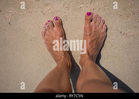 Feet on the pinkish sand Stock Photo