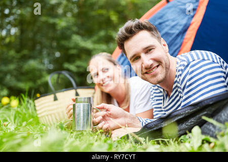 Young happy couple camping in the campsite is having a relaxed coffee Stock Photo