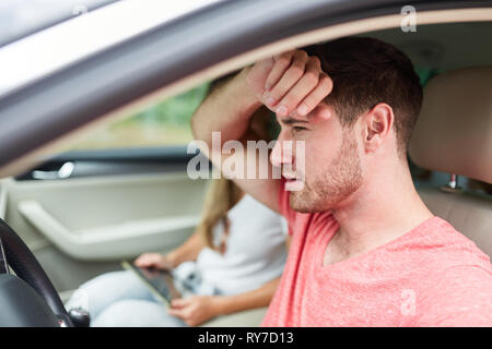 Young man in the car as a stressed and exhausted car driver Stock Photo