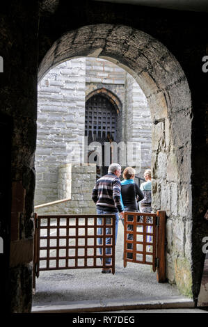 Visitors arriving at the main gated entrance to the 12th/13th century medieval built Castle Rushen in the centre of Castletown on the south coast of t Stock Photo