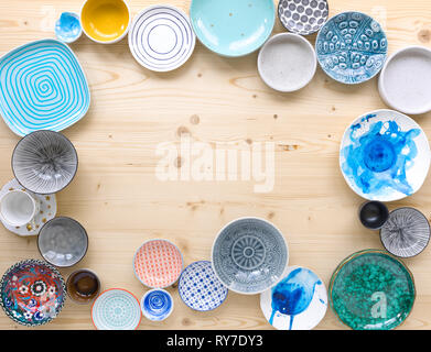 different kinds of modern colourful crockery on light wood background Stock Photo