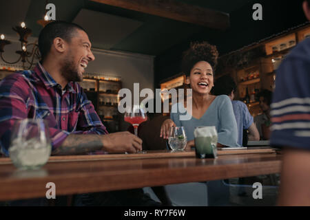 Friends having fun over drinks together in a bar Stock Photo
