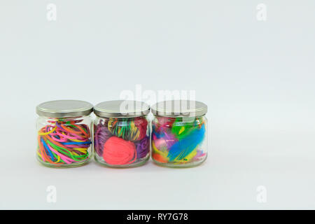 Glass jars filled with craft supplies with a white background Stock Photo