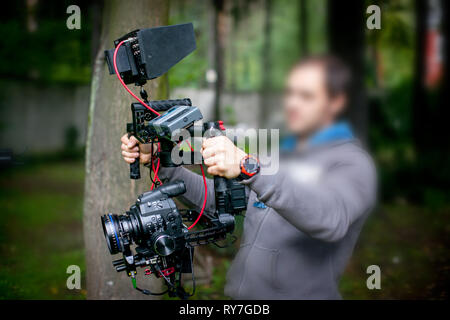 Blurry image of movie shooting or video production and film crew team with camera equipment at outdoor location Stock Photo