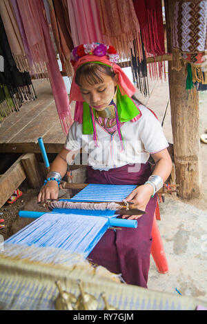Kayan woman in traditional clothing weaving by hand fabric on a hand loom. Ban Huai Seau Tao village NV Thailand (Mae Hong Son). Thailand. Stock Photo