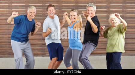 Lächelnde Senioren machen gemeinsam Piloxing im Fitnesscenter Stock Photo
