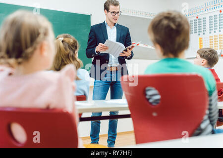 Teacher handing back written tests to the class Stock Photo