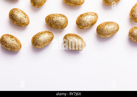Gold glitter easter eggs on a plain white background Stock Photo
