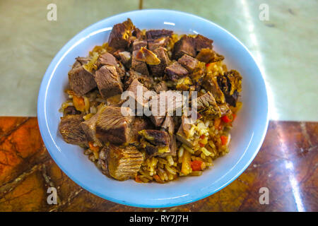 Kygryzstani Traditional Lamb Pilaf with Huge Meat Chunks on Rice in Bowl Stock Photo