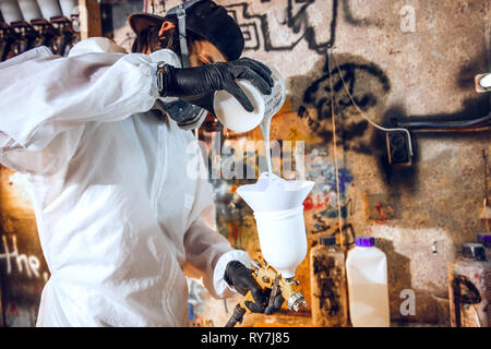 Master painter in a factory - industrial painting wood with spray gun. Stock Photo