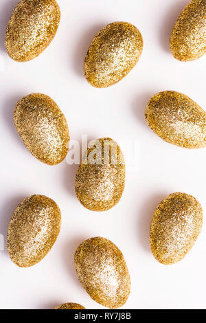 Gold glitter easter eggs on a plain white background Stock Photo