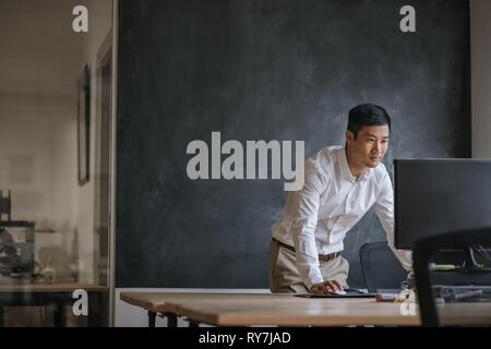 Asian businessman working on his computer in an office Stock Photo