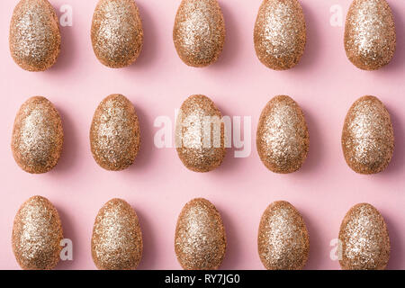 Gold glitter easter eggs on a pastel pink background. Happy Easter Stock Photo