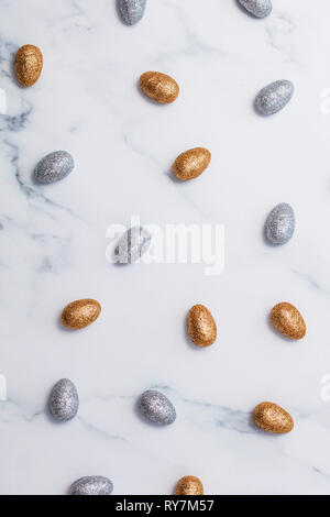 Gold and silver glitter easter eggs on a marble background Stock Photo