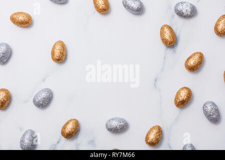 Gold and silver glitter easter eggs on a marble background Stock Photo