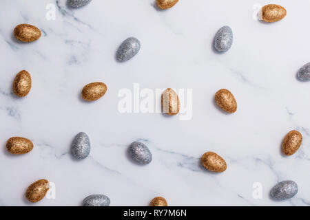 Gold and silver glitter easter eggs on a marble background Stock Photo