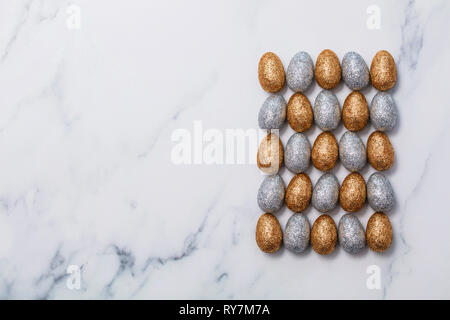 Gold and silver glitter easter eggs on a marble background Stock Photo