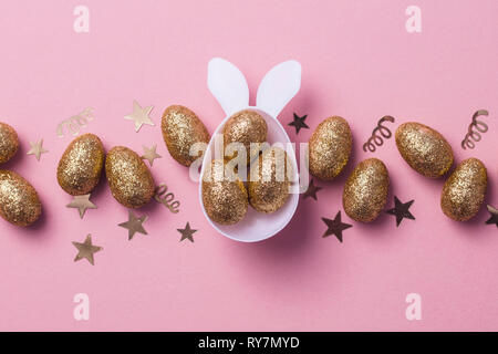 Gold glitter eggs in a white easter bunny egg shape with ears Stock Photo