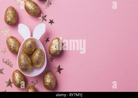 Gold glitter eggs in a white easter bunny egg shape with ears Stock Photo