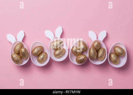 Gold glitter eggs in a white easter bunny egg shape with ears Stock Photo