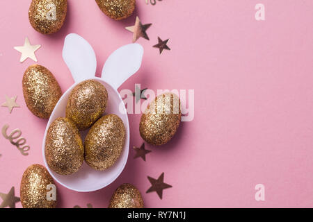 Gold glitter eggs in a white easter bunny egg shape with ears Stock Photo