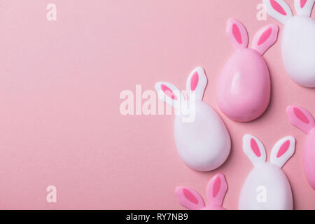 Easter eggs with bunny ears on a pastel pink background Stock Photo