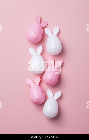 Easter eggs with bunny ears on a pastel pink background Stock Photo
