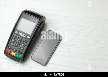 POS terminal, Payment Machine with mobile phone on white background. Contactless payment with NFC technology. Stock Photo
