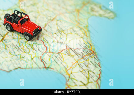 Travel on the road with map. Car travel and road trip. Concept of journey and rent a car. Selective focus, copy space. Stock Photo